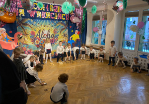 Dzieci schylają się po instrument, który leży przed nimi.