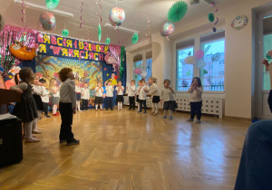 Przedszkolaki śpiewają piosenkę dla dziadków i pokazują jej treść za pomocą gestykulacji.