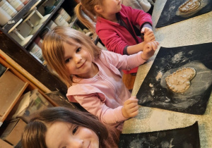 Trzy dziewczynki i dwóch chłopców prezentują wykonane przez siebie serduszka.