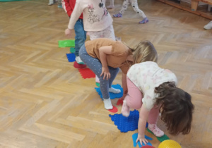 Dzieci przechodzą po kolei po torze sensorycznym.