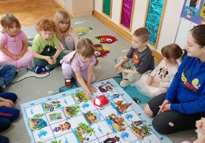 Dziewczynka programuje robota do przejazdu po macie.
