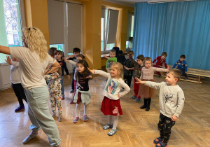 Dzieci wykonują ruchy i kroki taneczne według pani instruktor zumby.