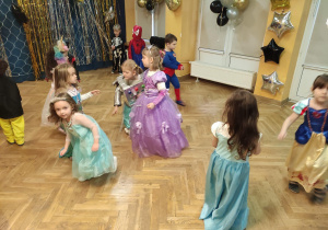 Dzieci tańczą swobodnie podczas balu karnawałowego.