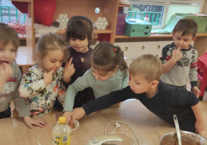 Dzieci degustują krem z miski.