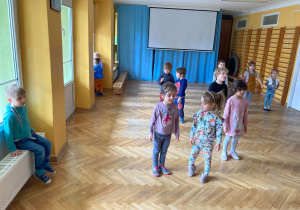 Dzieci swobodnie tańczą przy muzyce.