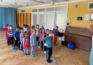 Dzieci stoją w dwóch rzędach podczas zajęć tanecznych z zumby.