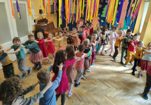 Dzieci tańczą przy muzyce tworząc pociąg.