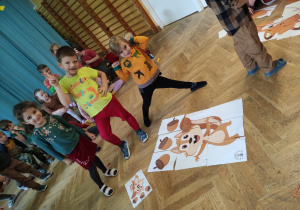 Dzieci prezentują ułożone giga puzzle z wizerunkiem wiewiórki z żołędziami.
