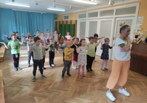 Dzieci z instruktorem zumby uczą się choreografii do nowego tańca.