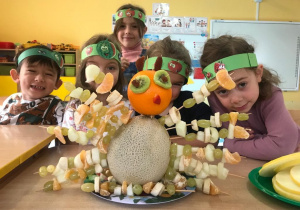 Dzieci siedzą przy stole prezentując swoją owocową "Sówkę".
