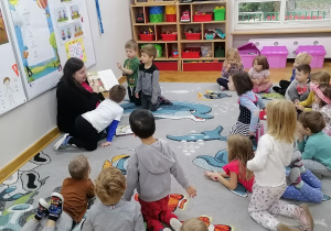 Akcja "Czytamy - głowy otwieramy". Mama Jasia pokazuje dzieciom ilustracje do czytanego przez siebie opowiadania.