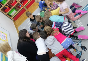 Akcja "Czytamy - głowy otwieramy". Dzieci wspólnie z mamą Jasia oglądają ilustracje zawarte w książce, którą mama czyta.