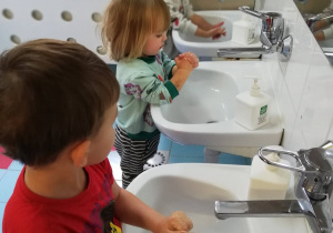 Chłopcy próbują samodzielnie umyć rączki w łazience.