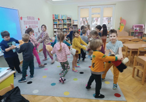 Dzieci tańczą w parach z kolegą, koleżanką i swoimi misiami przy szybkiej muzyce.