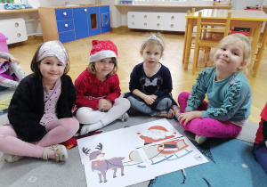 Cztery dziewczynki prezentują ułożone przez siebie puzzle ze Świętym Mikołajem.