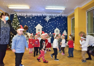 Dzieci podczas występu świątecznego tańczą po kole wspólnie z Paniami do piosenek świątecznych.
