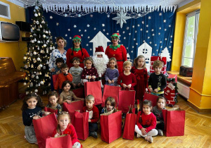 Dzieci wspólnie z Paniami, elfami i Świętym Mikołajem pozują do zdjęcia.