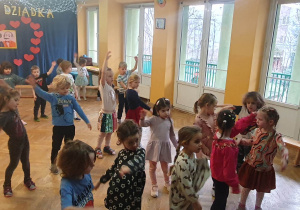 Dzieci tańczą na zajęciach zumby wymachując rączkami na boki.