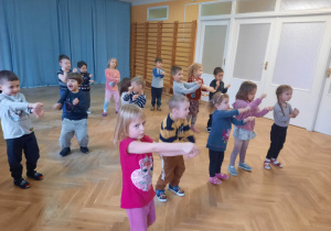 Dzieci tańczą do piosenki "Baby shark" z pokazywaniem.
