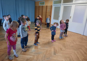 Dzieci powtarzają ruchy taneczne za trenerką zumby przy szybkiej muzyce.