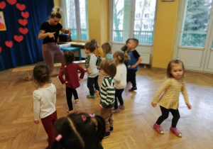 Dzieci powtarzają za trenerką zumby nowe kroki z choreografii tanecznej.
