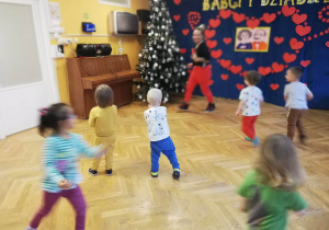 Dzieci powtarzają ruchy z układu tanecznego za trenerką zumby.