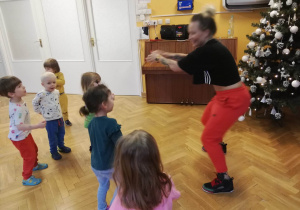 Dzieci powtarzają ruchy z układu tanecznego za trenerką zumby.