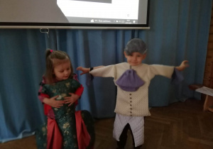Dzieci odgrywają scenkę przebrane w kostiumy aktorów z opery.