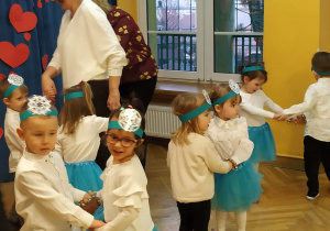 Dzieci tańczą w parach podczas występu dla dziadków.