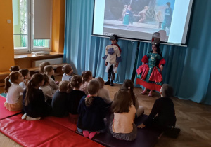 Dzieci odgrywają scenkę przebrane w kostiumy aktorów z opery.