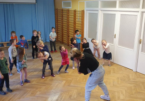 Dzieci uczą się kroków układu tanecznego pokazywanego przez Panią od zumby.