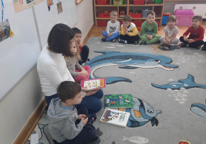 Akcja "Czytamy, głowy otwieramy", dzieci siedzą i słuchają, jak mama ich kolegi czyta im różne opowiadania.